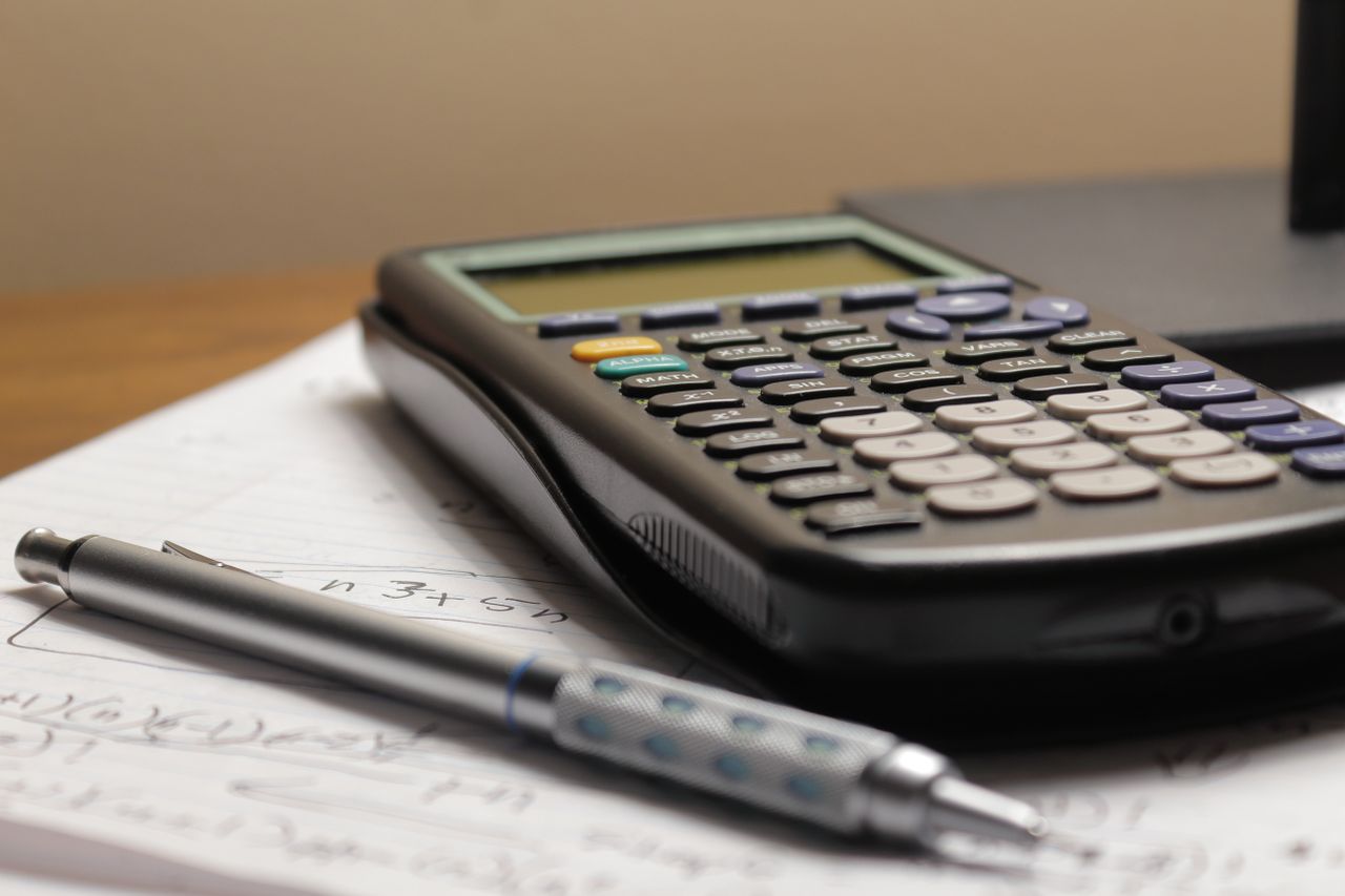services-01 A detailed view of a calculator and pen resting on mathematical notes, ideal for educational and financial themes.