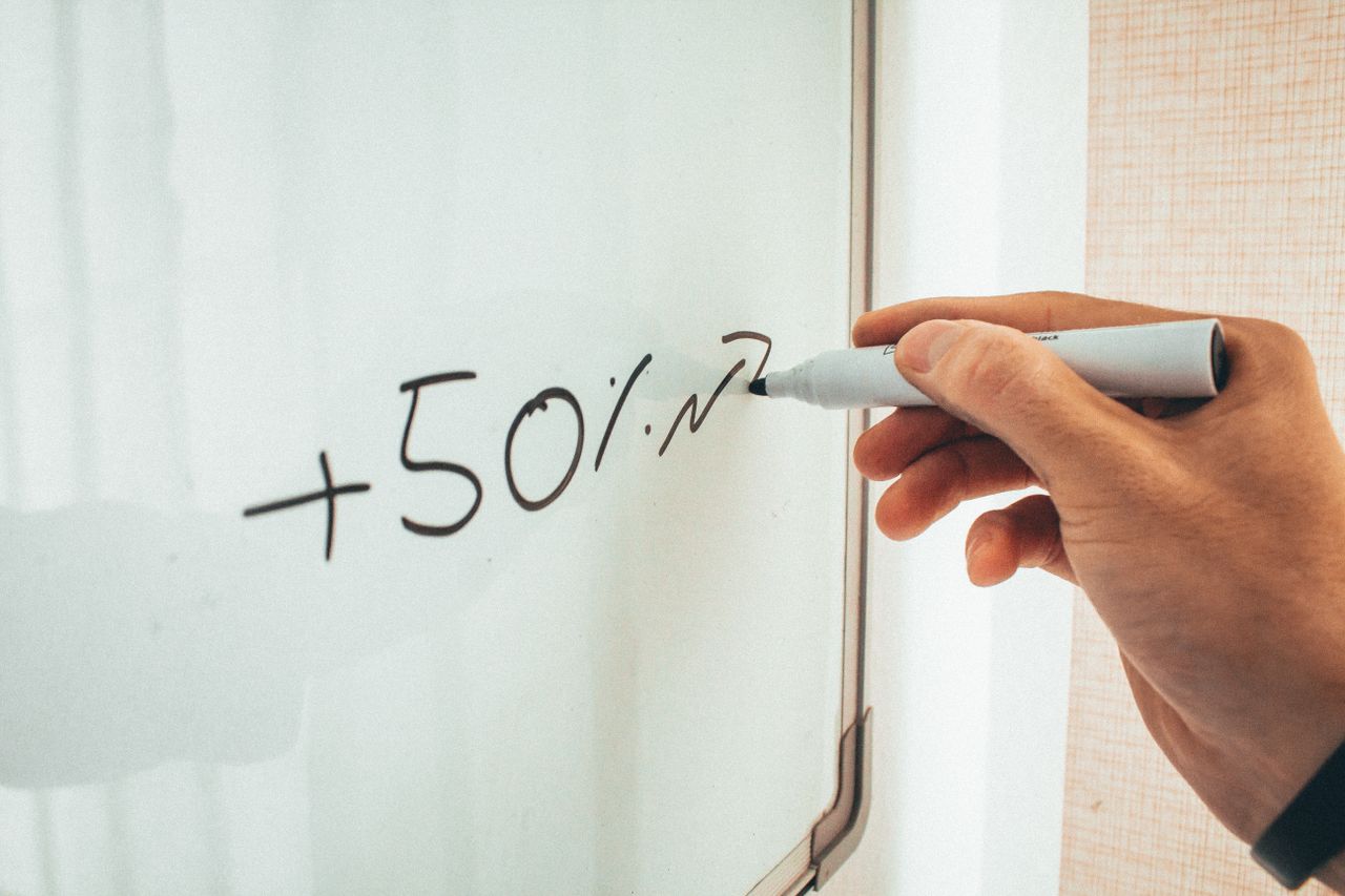 services-02 Crop anonymous male teacher writing math formulas on whiteboard during lessons in modern classroom